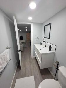 a white bathroom with a sink and a toilet at Gorgeous Basement Apartment in Calgary