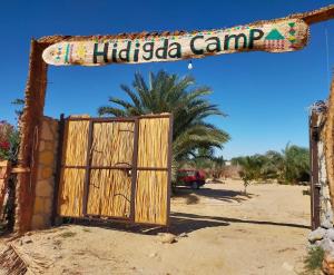 ein Holztor mit einem Schild, das Hitzka Camp liest in der Unterkunft Hidigda Camp in ‘Izbat Ţanāţī