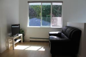 uma sala de estar com um sofá e uma televisão em Ocean Park B&B em Surrey
