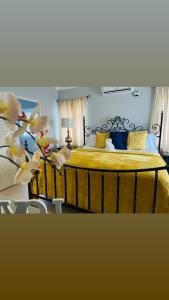 a bedroom with a large yellow bed with yellow pillows at Isle Be Back Villa in Priory