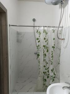 a bathroom with a shower curtain with a plant at Nomad Inn in Bishkek