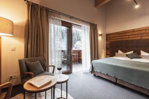 una camera d'albergo con letto, tavolo e sedie di Mulk Hotel - Joker Card included in Summer a Saalbach Hinterglemm