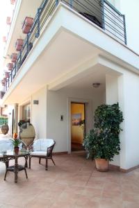 een patio met stoelen en een tafel en een gebouw bij B&B Villa il Sughero in Monopoli