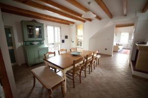 a kitchen and dining room with a wooden table and chairs at Casa Corte Giosuè Carducci in Specchia