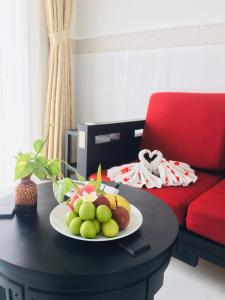 Ấp Thiện Phước的住宿－DYNASTY MUINE RESORT，红椅旁边的桌子上放着一盘水果