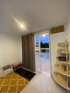 een woonkamer met een glazen schuifdeur en een balkon bij Villa Aslam Kayana Batu in Karangploso