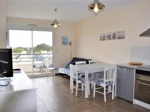 cocina y comedor con mesa y sillas en Appartement Trégastel, 3 pièces, 4 personnes - FR-1-368-11, en Trégastel