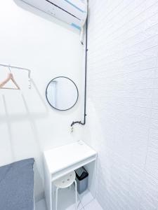 bagno bianco con lavandino e specchio di Stay Hub a Timuran