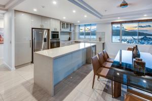 a kitchen with a large island and a table and chairs at Yacht Harbour Tower 2, Hamilton Island - Million Dollar Views, Buggy & Valet Service in Hamilton Island