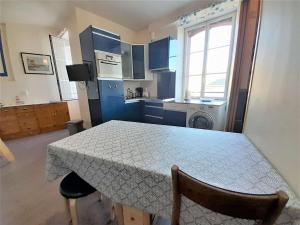 une cuisine avec une table et une cuisine avec des armoires bleues dans l'établissement Studio confortable 29m² pour 4 personnes au cœur de Quiberon, proximité plage - FR-1-478-175, à Quiberon