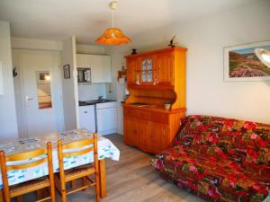 uma sala de estar com uma mesa e uma cama e uma cozinha em Appartement Quiberon, 2 pièces, 2 personnes - FR-1-478-166 em Quiberon