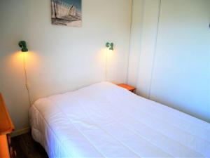 um quarto com uma cama branca com duas luzes em Appartement Quiberon, 2 pièces, 2 personnes - FR-1-478-166 em Quiberon