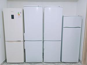 three white refrigerators are standing in a room at Nomad Inn in Bishkek