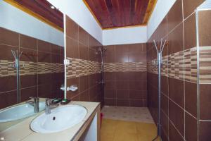 y baño con lavabo y ducha. en Hotel National Ambilobe, en Ambilobe