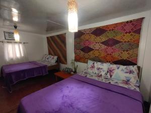 Postel nebo postele na pokoji v ubytování Purple Homestay Hillside