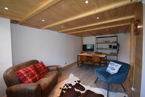 ein Wohnzimmer mit einem Sofa, Stühlen und einem Schreibtisch in der Unterkunft Résidence Grand Roc - Campanules 308 - Happy Rentals in Chamonix-Mont-Blanc