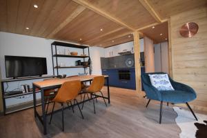 ein Esszimmer mit einem Tisch, Stühlen und einem TV in der Unterkunft Résidence Grand Roc - Campanules 308 - Happy Rentals in Chamonix-Mont-Blanc