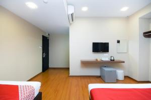 a room with two beds and a table in it at Super OYO 977 Hong Kong Suites in Miri