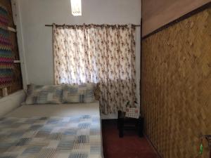 Habitación pequeña con cama y ventana en Purple Homestay en Corón