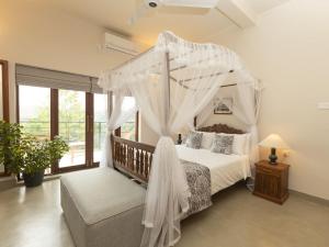 a bedroom with a canopy bed with white drapes at Edgar Mansion Kandy in Kandy