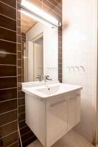 a bathroom with a white sink and a mirror at 2ndhomes Helsinki Center Apartment with Sauna in Helsinki