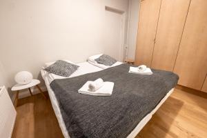 ヘルシンキにある2ndhomes Helsinki Center Apartment with Saunaのベッドルーム1室(ベッド2台、タオル付)
