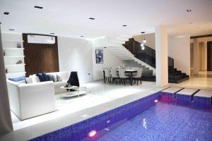 a living room with a swimming pool in a house at Cloud Villa Salalah in Salalah