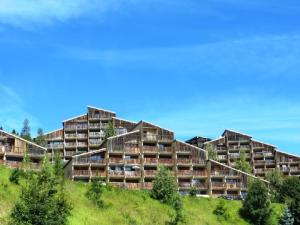 an apartment building on a hill with trees at Appartement Auris, 2 pièces, 6 personnes - FR-1-297-11 in Auris