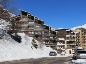 a large apartment building with cars parked in the snow at Appartement Auris, 1 pièce, 4 personnes - FR-1-297-25 in Auris