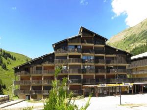 a large building with mountains in the background at Appartement Auris, 2 pièces, 6 personnes - FR-1-297-26 in Auris