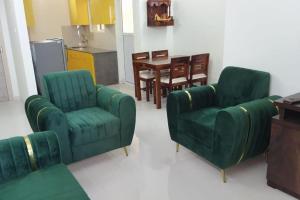 瓦斯科达伽马TATA Rio De Goa ,Goodstay 2 BHK Apartment With Pool ,6km from Airport ,201的客厅配有两张绿色椅子和一张桌子