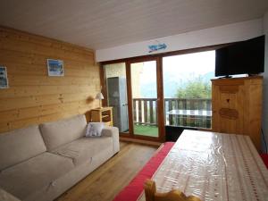 ein Wohnzimmer mit einem Sofa und einem großen Fenster in der Unterkunft Appartement Auris, 2 pièces, 8 personnes - FR-1-297-73 in Auris