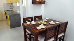 瓦斯科达伽马TATA Rio De Goa ,Goodstay 2 BHK Apartment With Pool ,6km from Airport ,201的厨房里一张木桌,上面放有水果盘
