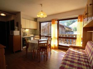 a kitchen and dining room with a table and chairs at Appartement Auris, 1 pièce, 4 personnes - FR-1-297-41 in Auris