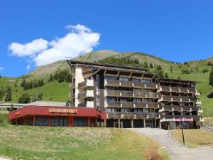 a large building with a mountain in the background at Appartement Auris, 1 pièce, 4 personnes - FR-1-297-117 in Auris