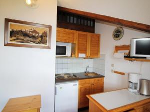 uma cozinha com um frigorífico branco e um micro-ondas em Appartement Auris, 1 pièce, 4 personnes - FR-1-297-60 em Auris