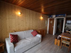 a living room with a couch and a wooden wall at Appartement Auris, 1 pièce, 4 personnes - FR-1-297-68 in Auris