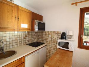 a small kitchen with a sink and a microwave at Appartement Auris, 3 pièces, 6 personnes - FR-1-297-77 in Auris
