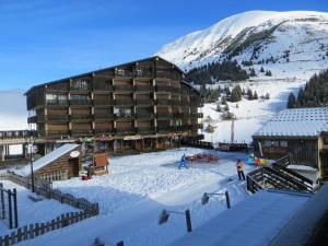 a ski lodge in the snow in front of a mountain at Appartement Auris, 3 pièces, 6 personnes - FR-1-297-77 in Auris