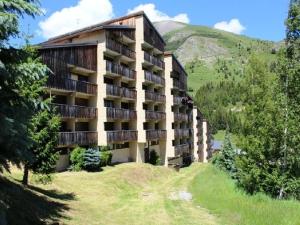 un bâtiment avec balcon sur le côté d'une colline dans l'établissement Studio cabine rénové au pied des pistes, 6 pers, proche services - FR-1-297-94, à Auris