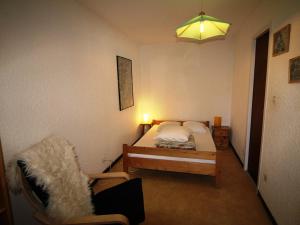 - une petite chambre avec un lit et une chaise dans l'établissement Appartement Auris, 2 pièces, 8 personnes - FR-1-297-101, à Auris