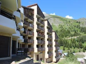 ein Gebäude mit Balkonen und einem Berg im Hintergrund in der Unterkunft Appartement Auris, 2 pièces, 4 personnes - FR-1-297-133 in Auris