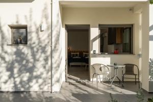 eine Terrasse mit Stühlen und einem Tisch in einem Haus in der Unterkunft Esperos Studios and Apartments, #2 in Stalida