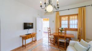 - un salon avec une table et une salle à manger dans l'établissement Apartamento Caracola Chipiona by Ruralidays, à Chipiona