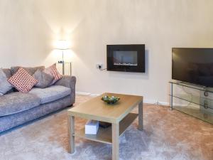 a living room with a couch and a tv at Sea Vista in Bognor Regis