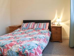 a bedroom with a bed and a night stand with a lamp at Sea Vista in Bognor Regis