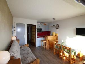a living room with a couch and a table at Studio cabine 4 pers au pied des pistes avec parking gratuit - Auris en Oisans - FR-1-297-151 in Auris