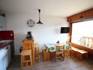 a kitchen with a table and chairs and a window at Studio cabine 4 pers au pied des pistes avec parking gratuit - Auris en Oisans - FR-1-297-151 in Auris +9 photos