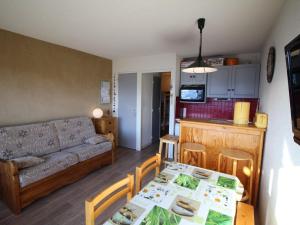 a living room with a couch and a table at Studio cabine 4 pers au pied des pistes avec parking gratuit - Auris en Oisans - FR-1-297-151 in Auris