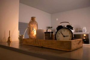 a clock on a table with a glass jar and a candle at Ferienwohnung "Frieda" in Breitenstein